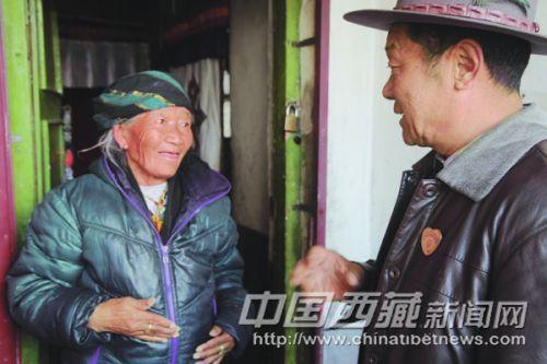 在黨的群眾路線教育實踐活動中，拉薩市城關(guān)區(qū)丹杰林社區(qū)民意組長、66歲的老黨員索朗積極為社區(qū)群眾辦實事，做好事，幫助社區(qū)里的老人與暫住居民解決實際困難，贏得了社區(qū)居民的一致稱贊。 圖為近日索朗在城關(guān)區(qū)丹杰林社區(qū)欽古巷了解卓瑪老人的生活困難。 記者 高加庫 攝